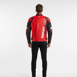 Puede incluir: Chaqueta de moto roja y negra con el texto "DUCATI CORSE" impreso verticalmente en la espalda. La chaqueta tiene mangas negras y detalles blancos en los hombros. La persona lleva pantalones negros.