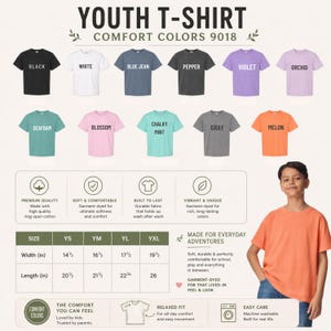 May include: A display of youth t-shirts in various colors, including black, white, blue jean, pepper, violet, and orchid. The image also shows the t-shirt's size chart, with widths ranging from 14.5 to 19.5 inches and lengths from 20.5 to 26 inches.