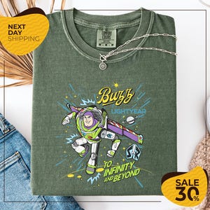 a green t-shirt with a colorful graphic of Buzz Lightyear from the Toy Story franchise, along with the text "Lightyear to Infinity and Beyond". The t-shirt is displayed on a white background, and there are yellow sale signs indicating a 30% discount.