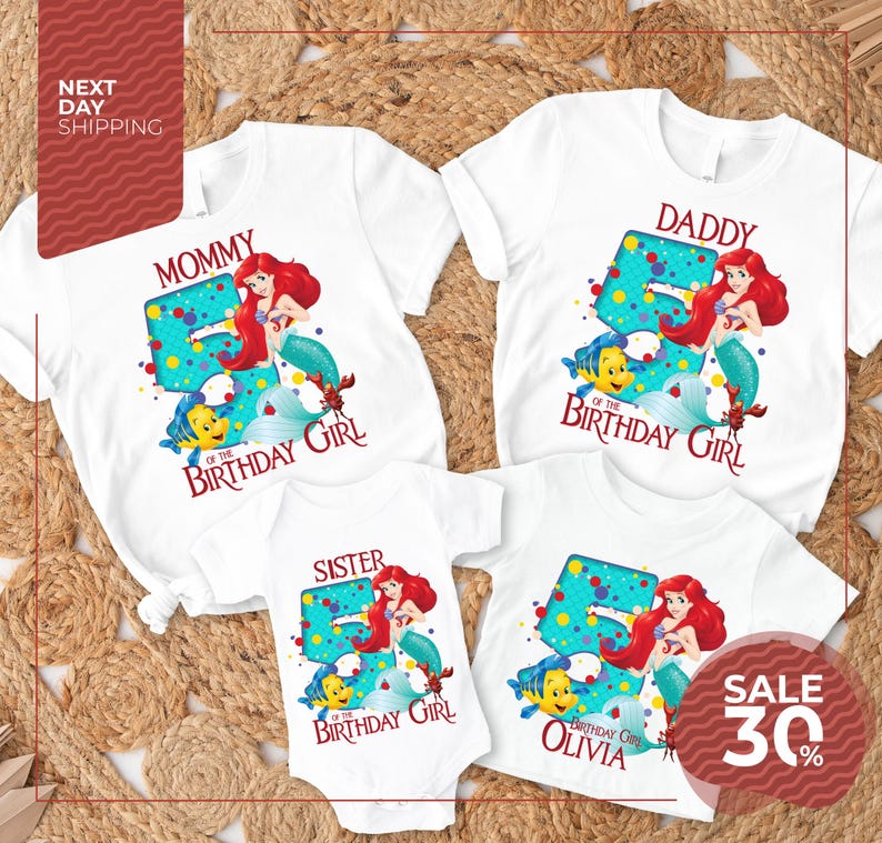 The image is a collection of four white t-shirts featuring the character Ariel from the Disney movie "The Little Mermaid". The t-shirts are designed for different age groups, with the largest one for a 5-year-old and the smallest one for a younger child. The t-shirts are arranged on a bed of straw, creating a visually appealing display.