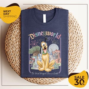 A t-shirt featuring a cartoon image of Pluto, the beloved character from the Disney animated film "Pluto". The t-shirt is displayed on a woven placemat, and there are two yellow price tags indicating a 30% discount on the item.