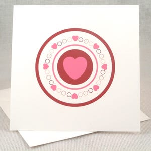 Tarjeta de San Valentín con forma de corazón y diseño de diana