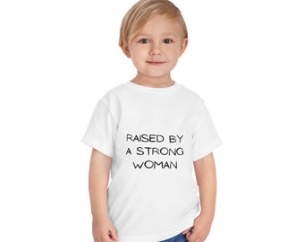 angehoben von einer starken Frau Kleinkind Tee | Feminist Slogan Kinder Shirt | Lustiges Kleinkind-T-Shirt | Kinder Empowerment Shirt | Mama Geschenk | Niedliches Kinder Outfit