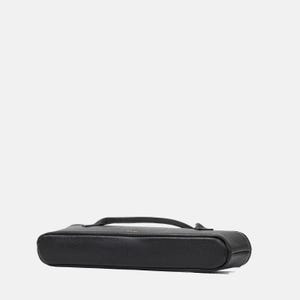 May include: A black, rectangular, pebbled-texture case with rounded corners and a slim profile. The case features a top-mounted handle and a zipper closure that runs along the perimeter, providing a secure and compact storage solution for small items.
