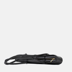 May include: A black pebbled leather tote bag laid horizontally, featuring a top zipper closure with a gold-toned metal pull, two long shoulder straps, and a structured rectangular base with visible stitching along the edges.