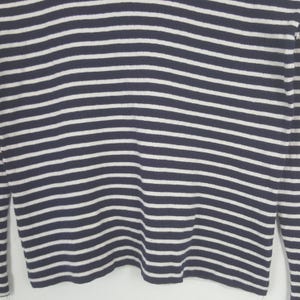 May include: Close-up of a navy blue and white striped long-sleeve shirt. The shirt features horizontal stripes in a classic nautical design. The sleeves are visible on either side of the frame, and the fabric appears to be a soft knit.