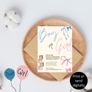 May include: A gender reveal party invitation with the words "Boy or Girl" in blue and pink script. The invitation includes pink and blue bows, wooden blocks spelling "BABY", and event details. The invitation is on a wooden plate with a kraft paper envelope.