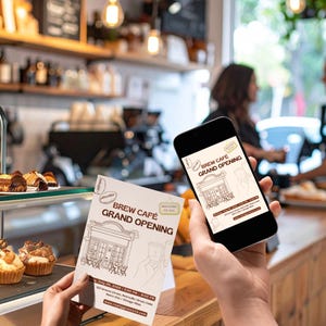 May include: A person holding a flyer and a smartphone, both displaying the text "Brew Cafe Grand Opening." The flyer and phone screen feature a line drawing of a cafe and event details. The background shows a cafe interior with pastries.