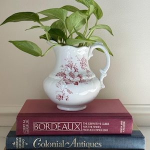 May include: A handmade, wooden cutting board with a natural finish. The board features a live edge on one side and a rectangular shape. It is approximately 18 inches long and 12 inches wide.