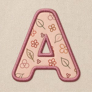 以下が含まれることがあります： 刺繍された文字「A」のパッチ、花柄。文字は薄いピンク色で、濃いピンク色の縁取り。花柄には、茶色とピンクの色合いの花と葉が含まれています。