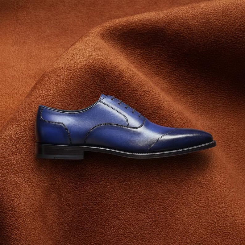 Veronatti handmade men's navy blue leather cap toe Oxford dress shoes, hand-burnished patina finish, side profile view on rust suede background