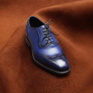 Front three-quarter view of Veronatti navy blue cap toe Oxford shoes highlighting lace-up design, stitched toe cap, and hand-burnished finish