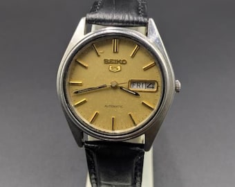 Klasyczny męski zegarek na rękę Seiko 5 z tarczą w kolorze złotym, wskaźnikiem daty i dnia tygodnia, z automatycznym mechanizmem