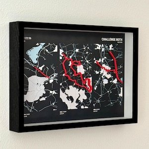 Könnte beinhalten: Ein gerahmtes Wandbild mit einer schwarzen Karte, weißen geografischen Details und roten erhabenen Linien, die eine Route nachzeichnen. Der Text "CHALLENGE ROTH" steht oben rechts. Das Bild befindet sich in einem schwarzen rechteckigen Rahmen.