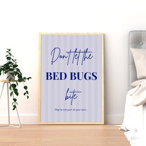 Puede incluir: Un cartel enmarcado con el texto "Don't let the BED BUGS bite" en azul marino sobre un fondo a rayas morado claro. La parte inferior del cartel dice "They're not part of your rent...". El marco es de color madera clara.