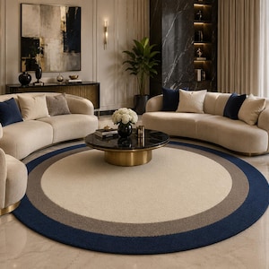 Könnte beinhalten: Ein modernes Wohnzimmer mit einem cremefarbenen, geschwungenen Sofa und marineblauen und beigen Zierkissen. Ein runder Teppich mit blauen, grauen und cremefarbenen konzentrischen Kreisen liegt in der Mitte. Ein schwarzer Couchtisch mit goldenem Sockel und ein großes abstraktes Gemälde vervollständigen die Szene.
