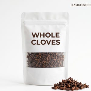 May include: A white pouch with a clear window displaying whole cloves. The text "WHOLE CLOVES" is printed in brown. A small pile of cloves is in front of the pouch. The brand name "RASIKESSENCE" is printed in the top right corner.