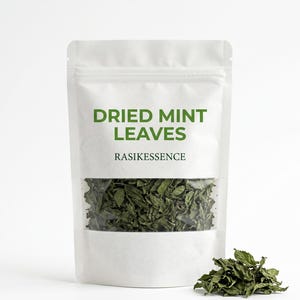 以下が含まれることがあります： 乾燥ミントの葉が入った透明窓付きの白い袋。テキスト「DRIED MINT LEAVES」は緑色で印刷され、下に「RASIKESSENCE」と書かれています。袋の前には、乾燥ミントの葉の小さな山があります。