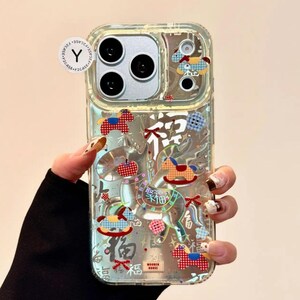 Puede incluir: Funda transparente para tel&eacute;fono con elementos decorativos coloridos, incluyendo caballos balanc&iacute;n y caracteres chinos. La funda tiene un dise&ntilde;o transparente, que permite ver el color del tel&eacute;fono. La funda tiene un recorte para la c&aacute;mara.