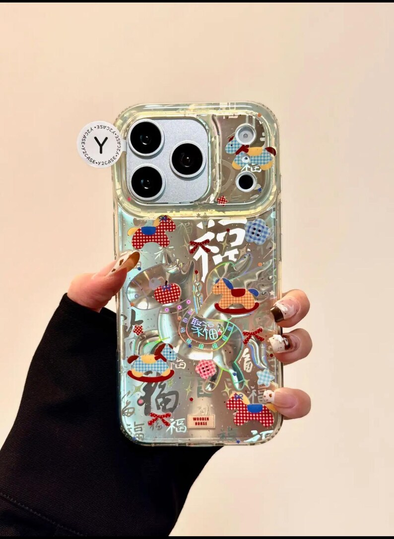 Puede incluir: Funda transparente para tel&eacute;fono con elementos decorativos coloridos, incluyendo caballos balanc&iacute;n y caracteres chinos. La funda tiene un dise&ntilde;o transparente, que permite ver el color del tel&eacute;fono. La funda tiene un recorte para la c&aacute;mara.