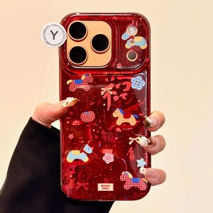 Puede incluir: Funda de tel&eacute;fono roja con un dise&ntilde;o transparente y brillante. La funda presenta un patr&oacute;n decorativo de caballos, nubes y caracteres chinos. La funda tiene forma rectangular con esquinas redondeadas.