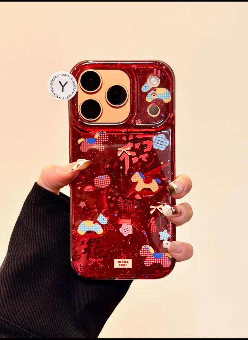 Puede incluir: Funda de tel&eacute;fono roja con un dise&ntilde;o transparente y brillante. La funda presenta un patr&oacute;n decorativo de caballos, nubes y caracteres chinos. La funda tiene forma rectangular con esquinas redondeadas.
