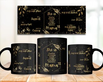 May include: Black ceramic mugs with gold text and accents. The mugs feature phrases like "She is Mama" and "my best friend." A matching wall art piece is above the mugs. The mugs are on a wooden surface.