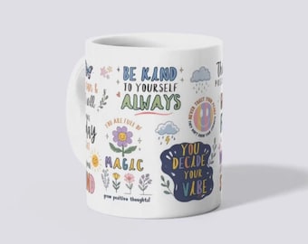May include: A white ceramic mug featuring a variety of colorful illustrations and motivational text including phrases like Be Kind To Yourself Always, You Are Full Of Magic, and You Decide Your Vibe, alongside icons of flowers, clouds, and a smiley face.