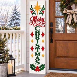 Könnte beinhalten: Ein hohes, rechteckiges weißes Holzschild für die Veranda mit dem roten Schriftzug Merry und dem grünen Wort CHRISTMAS in vertikaler Ausrichtung. Das Design zeigt einen gelben Stern, rote Beeren, grüne Stechpalmenblätter sowie rote und gelbe Rauten.