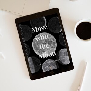 Könnte beinhalten: Ein schwarzes Tablet zeigt eine Grafik mit dem Text "Move with the Moon" und Mondphasen. Das Tablet liegt auf einer weißen Oberfläche mit einem Laptop, einer Tasse Kaffee und einem Stift.