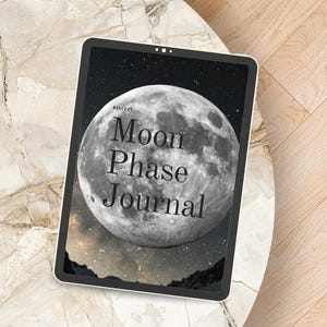 Könnte beinhalten: Ein digitales Tablet, das die Titelseite eines "Moon Phase Journal" anzeigt. Das Cover zeigt ein detailliertes Mondbild mit dem Text "Moon Phase Journal" in einer Serifenschrift. Der Hintergrund zeigt einen Sternenhimmel.