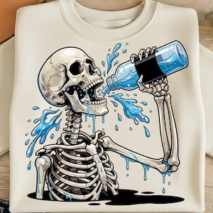 Può includere: Felpa color crema con una figura scheletrica che beve da una bottiglia d'acqua. Lo scheletro è dettagliato, con acqua che schizza dalla bocca e intorno alla bottiglia. L'acqua è di un blu vibrante, in contrasto con lo sfondo bianco sporco.