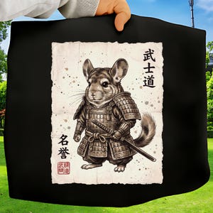 Op de afbeelding: Zwarte draagtas met een gedetailleerde illustratie van een chinchilla in samoerai-pantser, met een katana. Het kunstwerk is geplaatst tegen een achtergrond in perkamentstijl met Japanse tekst. De chinchilla is afgebeeld in grijstinten en bruin.