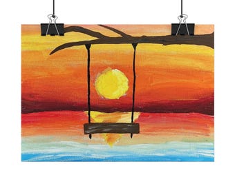 May include: A rectangular art print featuring a painted sunset scene with a bright yellow sun, orange and red sky, and a blue horizon. A dark brown tree branch extends across the top, holding a dark brown swing suspended by two vertical ropes.