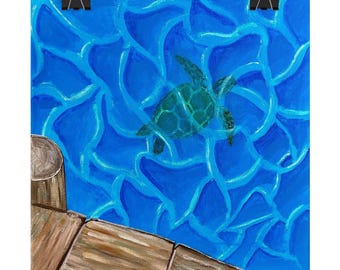 May include: A square wall art print featuring a green sea turtle swimming in vibrant blue water with light-refracting patterns. A brown wooden dock corner is visible in the lower left, and two black metal clips are attached to the top edge.