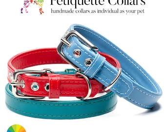 May include: Three leather dog collars in teal, red and light blue with silver buckles and stitching. The collars are stacked on top of each other. The text "Petiquette Collars" is visible above the collars. The text "handmade collars as individual as your pet" is also visible.