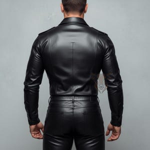 May include: A black leather jacket with a pointed collar, long sleeves, and shoulder epaulets, paired with matching black leather trousers featuring back pockets. The ensemble has a smooth, semi-gloss finish and a structured, fitted silhouette.