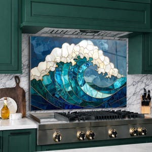 May include: A decorative kitchen backsplash featuring a mosaic wave design. The wave is composed of blue and teal tiles with gold accents, and white shell-like foam. The backsplash is installed above a stainless steel gas range.