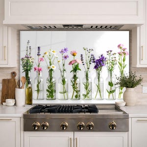 May include: A row of clear glass bottles, each holding a different type of fresh flowers. The flowers include daisies, lavender, and pink blooms. The bottles are arranged on a white surface, creating a bright and cheerful display.