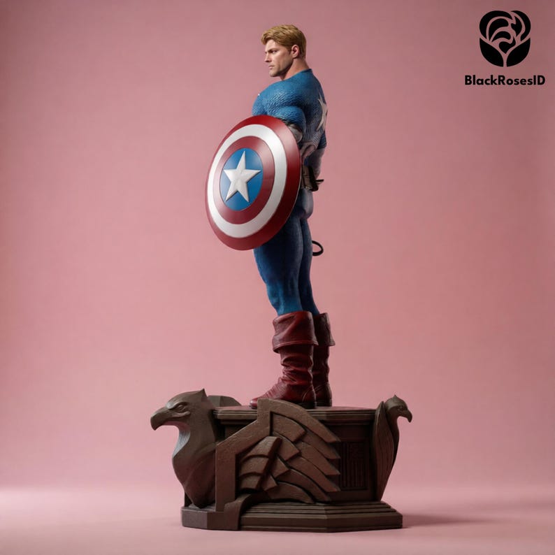 May include: A Captain America statue in a blue and red costume, holding a shield with a white star. The statue stands on a brown base with eagle carvings, set against a pink background. The figure is a collectible item.