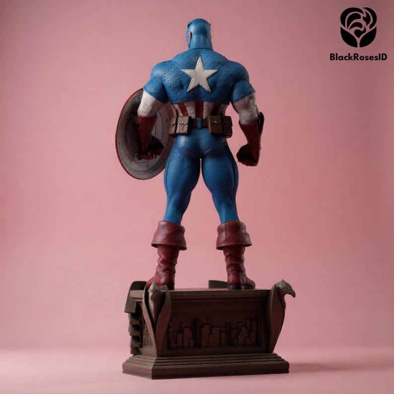 May include: A Captain America action figure, viewed from the back, stands on a detailed base. The figure wears a blue and white costume with a star emblem and holds a shield. The figure is approximately 12 inches tall.