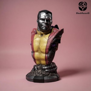 Op de afbeelding: Een gedetailleerde buste van een personage met een metallic zilveren hoofd en torso, gekleed in een geel en rood borststuk. Het figuur heeft een getextureerde, donkere basis en mechanisch ogende schouderdetails. De tekst BlackRosesID is zichtbaar.