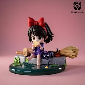 May include: A figurine of a young girl with black hair and a red bow eating a sandwich. She is sitting on a stone platform with a black cat and a broom. The base is a pond with lily pads and a splash of water. The background is pink.