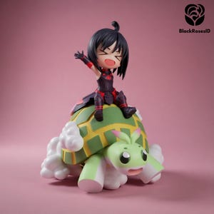 May include: A figurine of a cartoon character with black hair and a red and black outfit, riding a green and yellow turtle-like creature with white accents. The figurine is set against a pink background. The text "BlackRosesID" is in the upper right corner.