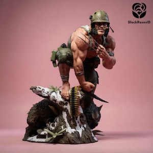 May include: A detailed figurine of a muscular character wearing a green military helmet and pants, featuring three metallic claws extending from one hand. The figure stands on a textured base resembling a snow-covered tree stump with ammunition.