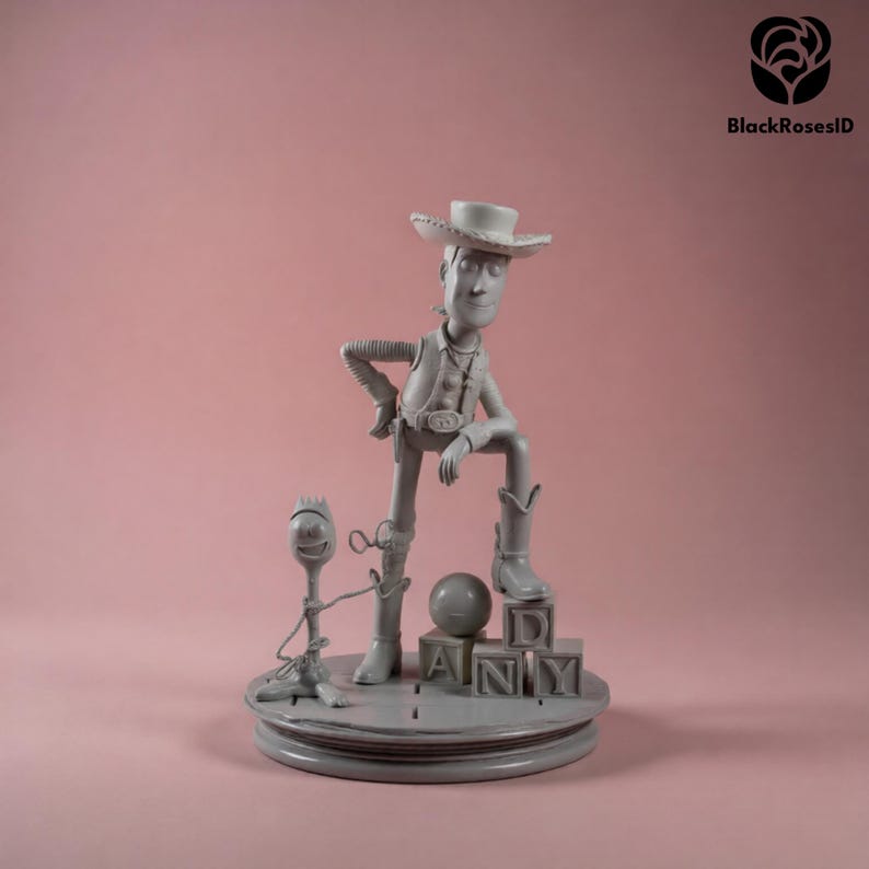 K&ouml;nnte beinhalten: Graue Figur von Woody aus Toy Story, posiert mit einem Bein auf Bl&ouml;cken, die "ANDY" buchstabieren. Eine kleinere Forky-Figur steht in der N&auml;he. Der Sockel ist rund und der Hintergrund ist einfarbig rosa.