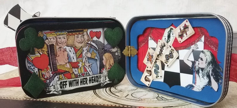 May include: A vintage tin box with a black and white illustration of playing cards and the text "Off with her head!" on the front. The back of the box has a blue frame with a red curtain and a chessboard with playing cards falling from the top.