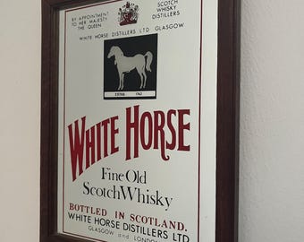 May include: A rectangular wall mirror in a dark brown wooden frame featuring a White Horse Fine Old Scotch Whisky advertisement. The print includes a black square with a white horse silhouette, the text "ESTAB. 1742," and "BY APPOINTMENT TO HER MAJESTY THE QUEEN."