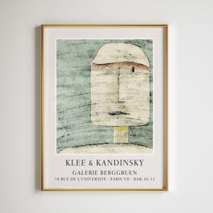 Puede incluir: Lámina artística enmarcada en dorado que representa un rostro estilizado con sombrero, en tonos beige, rojo y azul. La impresión incluye el texto "KLEE & KANDINSKY GALERIE BERGGRUEN 70 RUE DE L'UNIVERSITÉ PARIS VII BAB. 02-12".