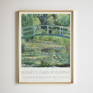 Puede incluir: Una impresión enmarcada de "Nenúfares" de Monet, con un puente verde sobre un estanque lleno de nenúfares. La obra de arte está en un marco dorado, con el texto "MONET'S YEARS AT GIVERNY" en la parte inferior.
